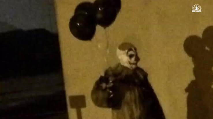Clown with balloons at night
