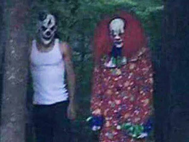 Two masked clown figures outdoors